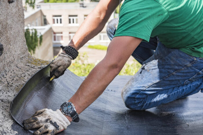 worker-performs-overhaul-roof-residential-building (1) Commercial Roofing